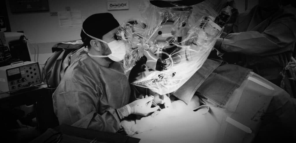 Roni Prucz MD using a microscope to perform surgery